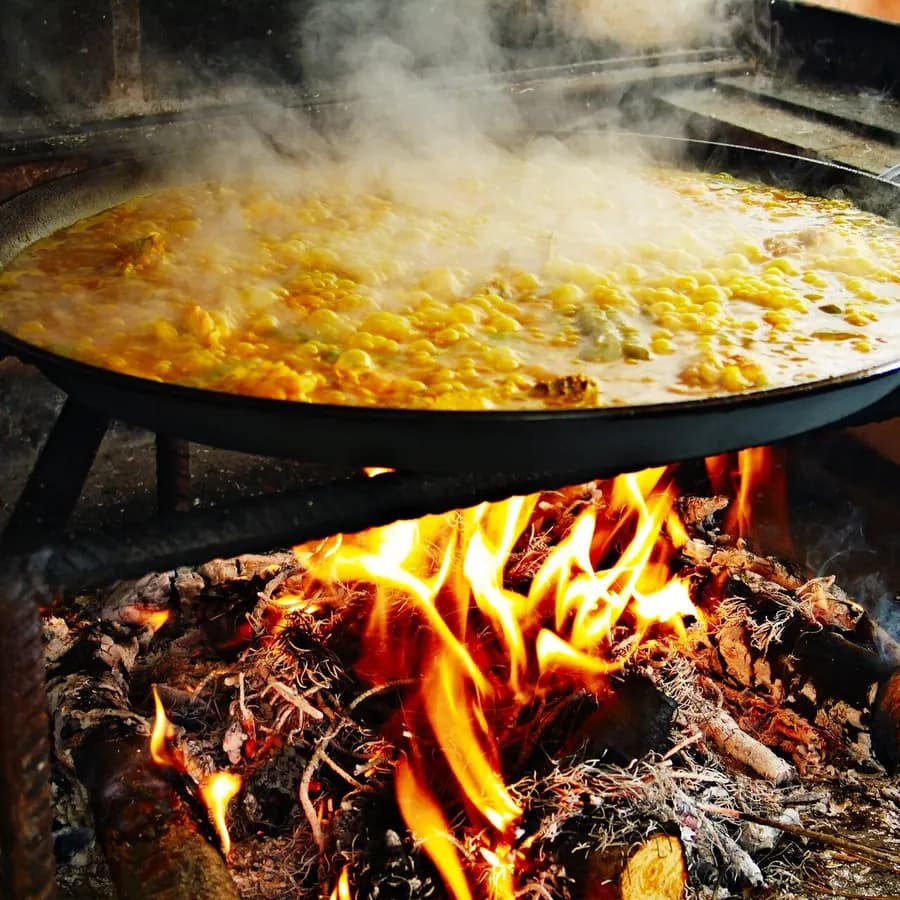 Steaming paella over a fire