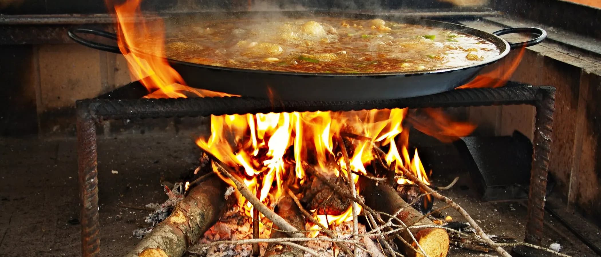 Paella cooking over an open wood fire